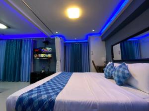a bedroom with a large bed with blue lighting at TLT Condotl at Kiener Hills Condominium in Mactan