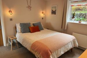 a bedroom with a bed and a window at The Burrow Devon in Longdown