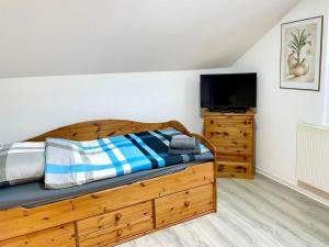 a bedroom with a wooden bed and a flat screen tv at Spacious Work & Relax in Lennestadt