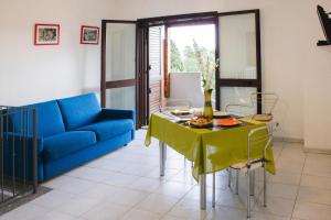 een woonkamer met een blauwe bank en een tafel bij Apartment in Santa Margherita di Pula in Santa Margherita di Pula