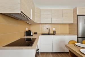 - une cuisine avec des placards blancs et un évier dans l'établissement 864 Suite Iris - Superb apartment, à Montreuil