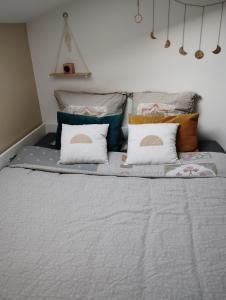 Un dormitorio con una cama con almohadas. en Lodge 2 étoiles la tête dans les pins les pieds dans l eau en Lacanau