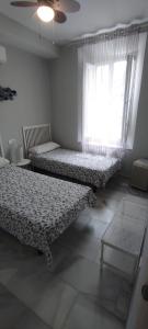 マラガにあるLovely Apartment in Pedregalejoのベッドルーム1室(ベッド2台、窓付)