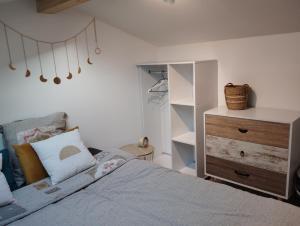 a bedroom with a bed and a wooden dresser at Lodge 2 étoiles la tête dans les pins les pieds dans l eau in Lacanau