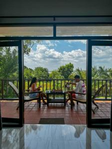 un hombre y una mujer sentados en sillas en un porche en Ashansa Lagoon Resort, en Tangalle