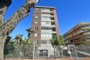 a tall building with a fence in front of it at Morakani Studio 503 in Green Point. in Cape Town