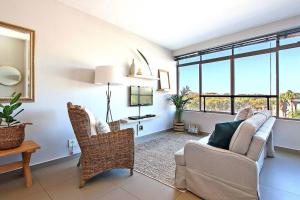 a living room with a couch and chairs and windows at Morakani Studio 503 in Green Point. in Cape Town