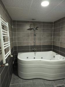 y baño con bañera y azulejos marrones. en White Crown Apartman ve Yaşam Merkezi, en Estambul