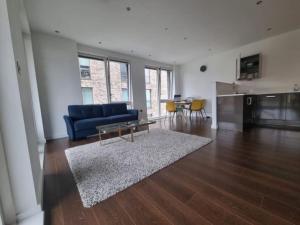 a living room with a blue couch and a table at ExCeL London-Exclusive 3 Bedroom in North Woolwich