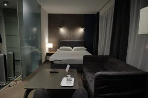 AndrespolにあるAzymut Hotel & Restaurantのベッドルーム1室(ベッド1台、ソファ、テーブル付)