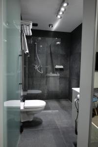 y baño con ducha, aseo y lavamanos. en Azymut Hotel & Restaurant en Andrespol