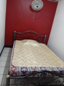 Cama en habitación con pared roja en SP House RoiEd, en Roi Et
