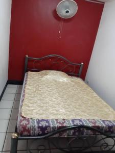 a bed in a room with a red wall at SP House RoiEd in Roi Et +11 photos
