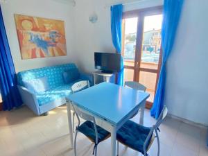 a living room with a blue table and chairs and a couch at Appartamento Lucca 2 in San Teodoro