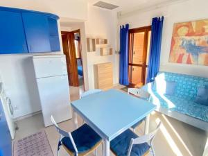 a kitchen with a blue table and chairs at Appartamento Lucca 2 in San Teodoro +9 photos