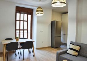 een keuken en een woonkamer met een tafel en stoelen bij La Colegiata Suite in Lorca