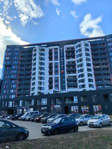 a large building with cars parked in a parking lot at Luxury Apartment/Studio in Plovdiv