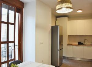 a kitchen with a stainless steel refrigerator and a window at La Colegiata Suite in Lorca