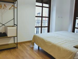 1 dormitorio con cama y ventana grande en La Colegiata Suite, en Lorca