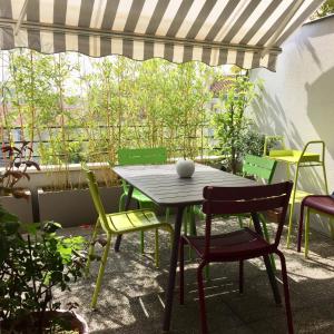 une table et des chaises sur une terrasse avec une fenêtre dans l'établissement Junior suite avec balcon, à Lyon