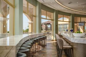 a bar with a row of stools in a restaurant at Lindos Imperial Resort & Spa in Kiotari