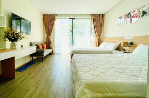 Cette chambre comprend deux lits et un bureau. dans l'établissement Căn hộ nghỉ dưỡng 5 sao APEC MANDALA PHÚ YÊN, à Liên Trì (3)