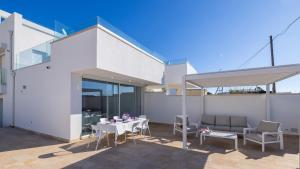 Un patio con mesa y sillas y un edificio. en VILLA RISTOLA 6, Emma Villas, en Leuca