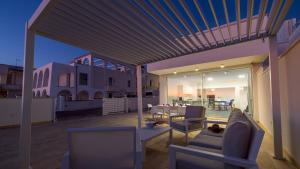 un patio con mesa y sillas en un edificio en VILLA RISTOLA 6, Emma Villas, en Leuca