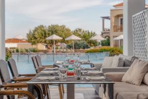 a table with glasses on it next to a pool at Lindos Imperial Resort & Spa in Kiotari