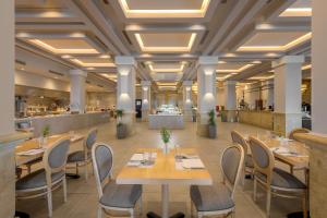 a restaurant with tables and chairs in a room at Lindos Imperial Resort & Spa in Kiotari