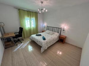 a bedroom with a bed and a desk and a chair at Book Jet - Villa Vacacional libertad Pajara 