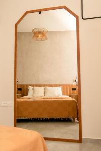 espejo en un dormitorio con cama y lámpara en Casa De Lago Superior en Ágios Nikólaos