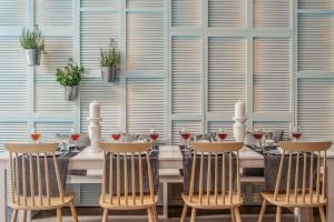 a table with four chairs and wine glasses at Lindos Imperial Resort & Spa in Kiotari