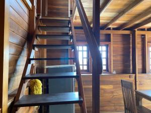 a wooden staircase in a cabin with a table and chairs at Diwan Apartment & Chalet in Colombo