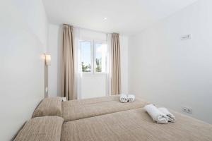 ein Schlafzimmer mit 2 Betten und Handtüchern darauf in der Unterkunft Villa Feli in Cala'n Bosch