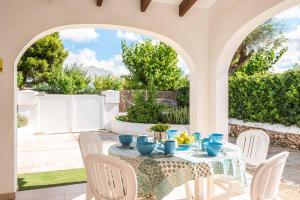 a table with blue dishes on it under an archway at Villa Tia Dora in Cala en Blanes