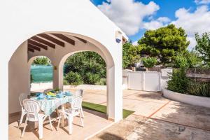 a patio with a table and chairs and the ocean at Villa Tia Dora in Cala en Blanes