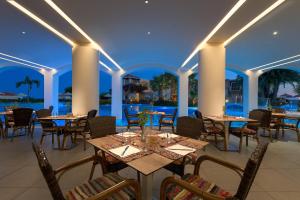 a restaurant with tables and chairs and a view of the ocean at Lindos Imperial Resort & Spa in Kiotari