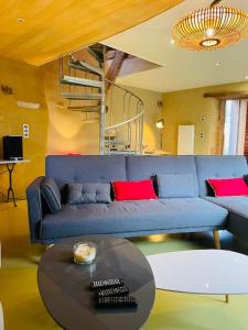 sala de estar con sofá azul y mesa en Gîte Les Grangettes*Piscine*Cadre bucolique, en Campagnac-lès-Quercy