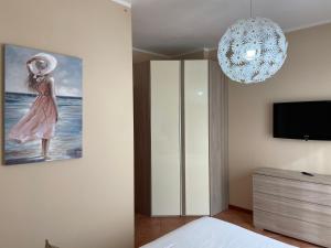 una camera da letto con un dipinto e un lampadario a braccio di Appartamento linea diretta Duomo a Milano