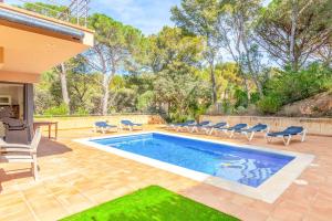 una piscina en un patio con sillas alrededor en Villa Vista Alegre, en Palafrugell