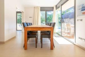 una sala da pranzo con tavolo e sedie in legno di Villa Vista Alegre a Palafrugell