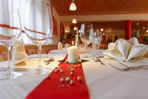 una mesa con copas de vino y una vela en ella en Hotel Restaurant Talblick, en Bad Ditzenbach