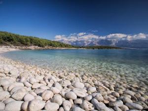 a large body of water with rocks on the shore at Apartment Tara in Sumartin