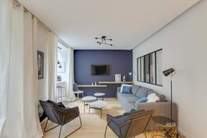 a living room with a couch and chairs at 140 Suite Ludo - Superbe Appartement à Paris in Paris