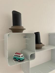 een speelgoedbusje op een plank met twee hoeden bij Newly built bright apartment, close to everything. in Nacka
