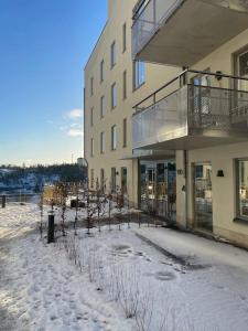 een gebouw met sneeuw op de grond ervoor bij Newly built bright apartment, close to everything. in Nacka