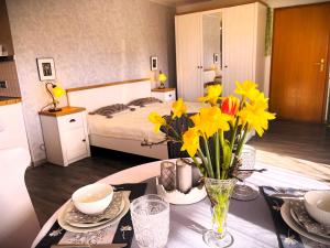 ein Zimmer mit einem Tisch mit gelben Blumen darauf in der Unterkunft Ferienwohnung Angelika in Kressbronn am Bodensee