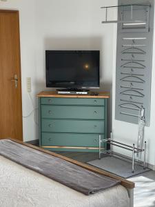 Schlafzimmer mit einem TV auf der Kommode in der Unterkunft Ferienwohnung Angelika in Kressbronn am Bodensee