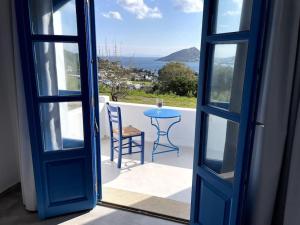 una puerta abierta a un patio con mesa y silla en Villa Keroula, en Alinda